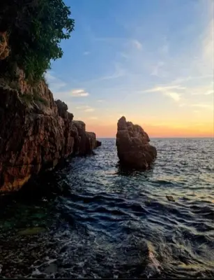 a group of rocks in the water near the ocean at HELEN LUX Apartments in Dobra Voda