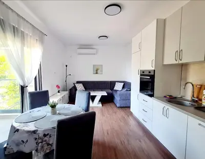 a kitchen and living room with a table in a room at HELEN LUX Apartments in Dobra Voda
