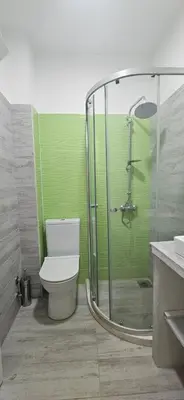 a bathroom with a toilet and a glass shower at Hotel Kunjui in Utjeha