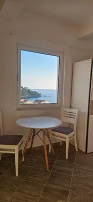 a table and two chairs in a room with a window at Hotel Kunjui in Utjeha