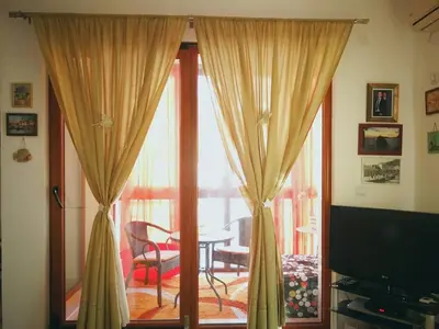 a living room with a sliding glass door with a table and chairs at Gerbera Budva Montenegro in Budva