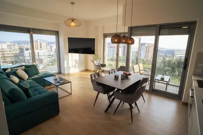 a living room with a green couch and a table at FAVEHOME Apartment Sea View Pool Parking 2 Bedrooms Near Beach in Bar