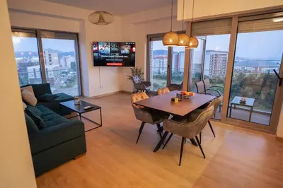 a living room with a table and a couch and a tv at FAVEHOME Apartment Sea View Pool Parking 2 Bedrooms Near Beach in Bar