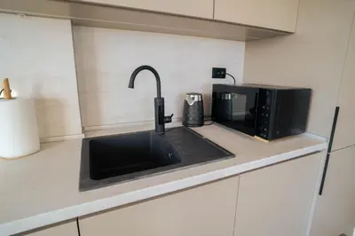 a kitchen counter with a sink and a microwave at FAVEHOME Apartment Sea View Pool Parking 2 Bedrooms Near Beach in Bar