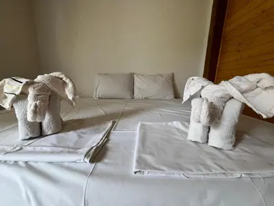 a white bed with towels on top of it at Apartmani Jana in Sutomore