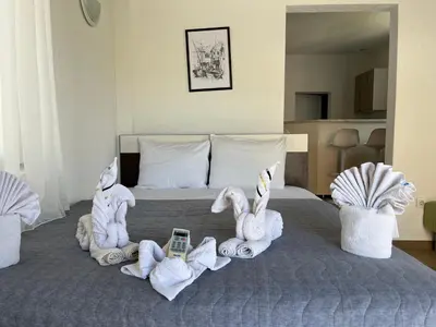 a bed with towels and a cell phone on it at Apartmani Jana in Sutomore