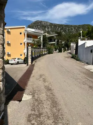 an empty street with buildings and a mountain in the background at Apartmani Jana in Sutomore