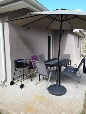 a table and chairs under an umbrella on a patio at House Kona in Zupci