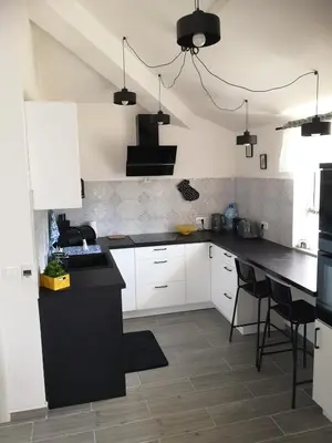 a kitchen with white cabinets and a black counter top at House Kona in Zupci