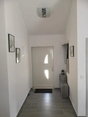 a hallway with white walls and a white door at House Kona in Zupci