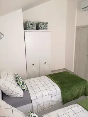 a bedroom with a bed with a green blanket at House Kona in Zupci