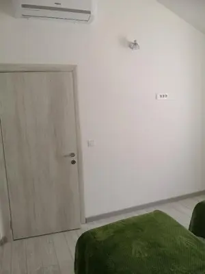 a white room with a door and a green blanket at House Kona in Zupci
