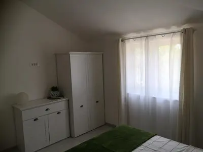 a bedroom with a bed and a dresser and a window at House Kona in Zupci