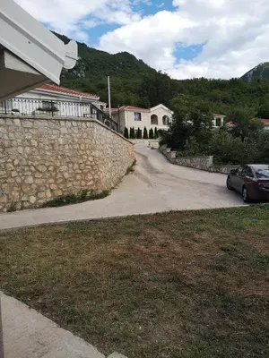a road with a stone wall and a car on it at House Kona in Zupci