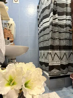 a bathroom with a sink and a shower with white flowers at Coral apartment in Budva