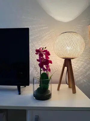 a desk with a lamp and a flower in a vase at Coral apartment in Budva