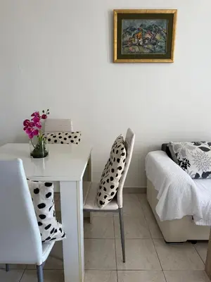 a room with a white table and chairs and a bed at Coral apartment in Budva