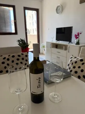 a bottle of wine and two glasses on a table at Coral apartment in Budva