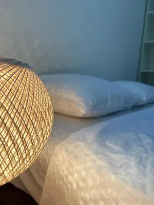 a bed with a pillow and a straw hat on it at Coral apartment in Budva