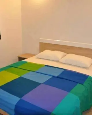 a bed with a colorful comforter in a bedroom at Konak in Donji Štoj
