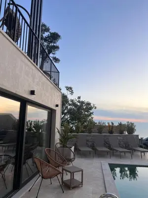 a patio with chairs and a pool on a building at Vila panorama in Budva