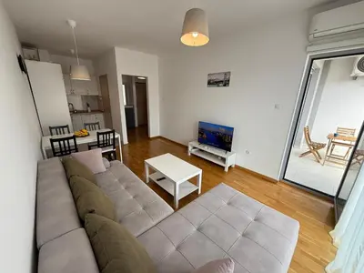 a living room with a couch and a table at Mediterano apartment Becici in Budva