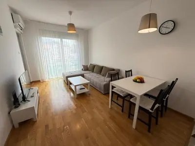 a living room with a table and a couch at Mediterano apartment Becici in Budva