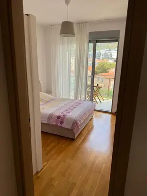 a bedroom with a bed and a view of a balcony at Mediterano apartment Becici in Budva