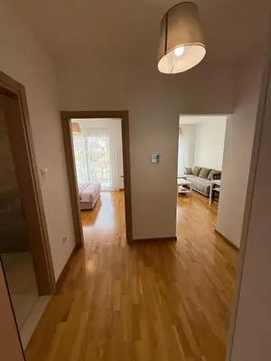 a living room with a hard wood floor and a couch at Mediterano apartment Becici in Budva