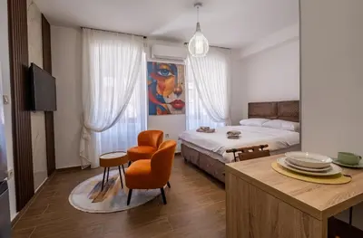a bedroom with a bed and a table and chairs at Apartman Ksenija in Cetinje