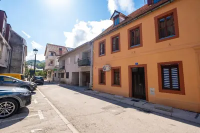 a street with buildings and a car parked on the street at Apartman Ksenija in Cetinje