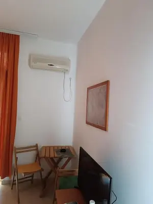 a living room with a tv and a table with a desk at Budva obala in Budva