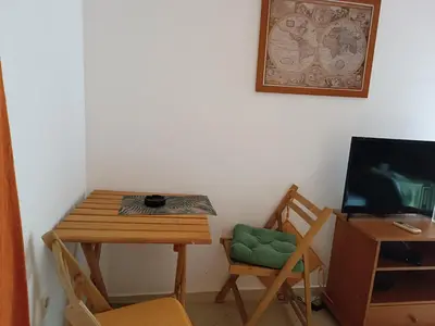 a room with a table and a chair and a television at Budva obala in Budva