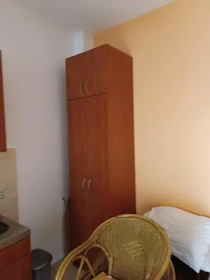 a bedroom with a wooden cabinet next to a bed at Budva obala in Budva