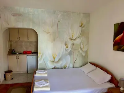 a bedroom with a white flower mural on the wall at Apartmani Vedrana Sutomore in Sutomore