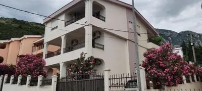 a building with pink flowers in front of it at Apartmani Vedrana Sutomore in Sutomore