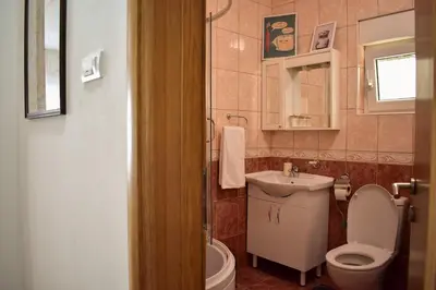 a bathroom with a toilet and a sink at Olivers Cozy and Spacious Apt in Podgorica