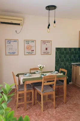 a dining room with a table and four chairs at Olivers Cozy and Spacious Apt in Podgorica
