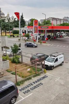 a parking lot with cars parked in front of a gas station at Olivers Cozy and Spacious Apt in Podgorica
