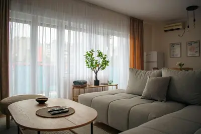 a living room with a couch and a table at Olivers Cozy and Spacious Apt in Podgorica