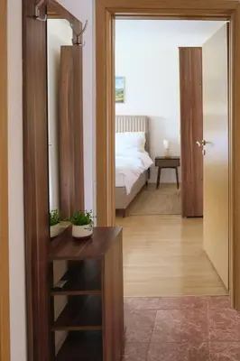 a room with a bedroom with a bed and a table at Olivers Cozy and Spacious Apt in Podgorica