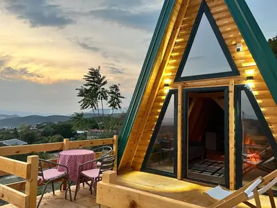 a cabin with a deck with a table and chairs at Podgoricka Koliba