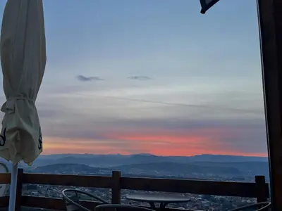 a view of a sunset from a table and an umbrella at Podgoricka Koliba