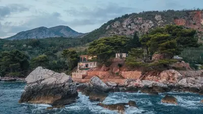 a house on a rocky island in the water at Art Residence Holiday Home in Bar