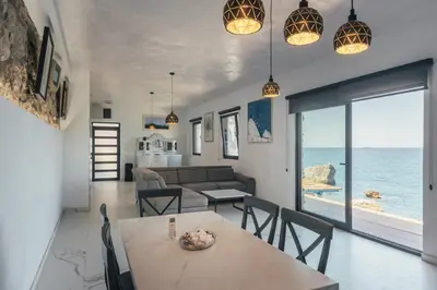 a living room with a table and chairs and the ocean at Art Residence Holiday Home in Bar