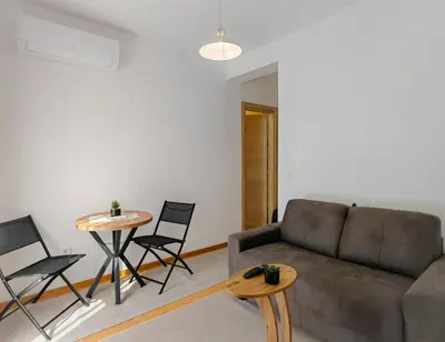 a living room with a couch and two tables and chairs at Modern City Apartment Budva 2-Central Location,5 min to Beach in Kravlja