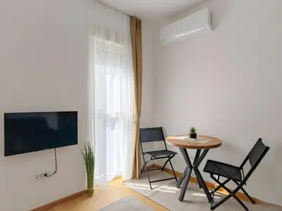 a living room with a table and chairs and a tv at Modern City Apartment Budva 2-Central Location,5 min to Beach in Kravlja