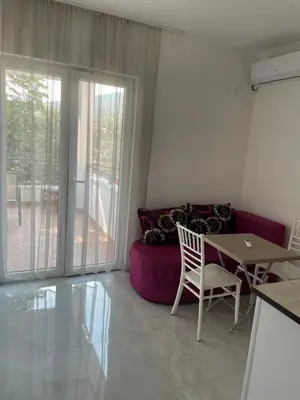 a living room with a table and a purple couch at Revea in Budva