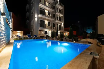 a large blue swimming pool in front of a building at Cozy Studio 11 Budvablue with Pool - Parking in Budva