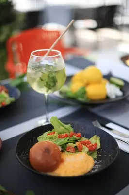 a table with plates of food and a glass of wine at Skyline Sunset in Becici